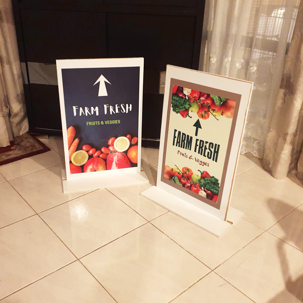 Two double sided printed counter signage stands for a fresh produce display