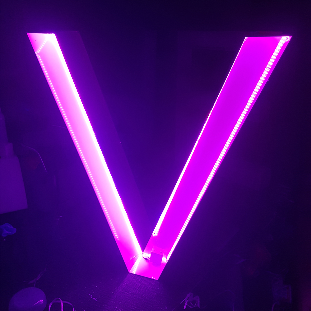 LED lit acrylic letter signage glowing pink in a dark room